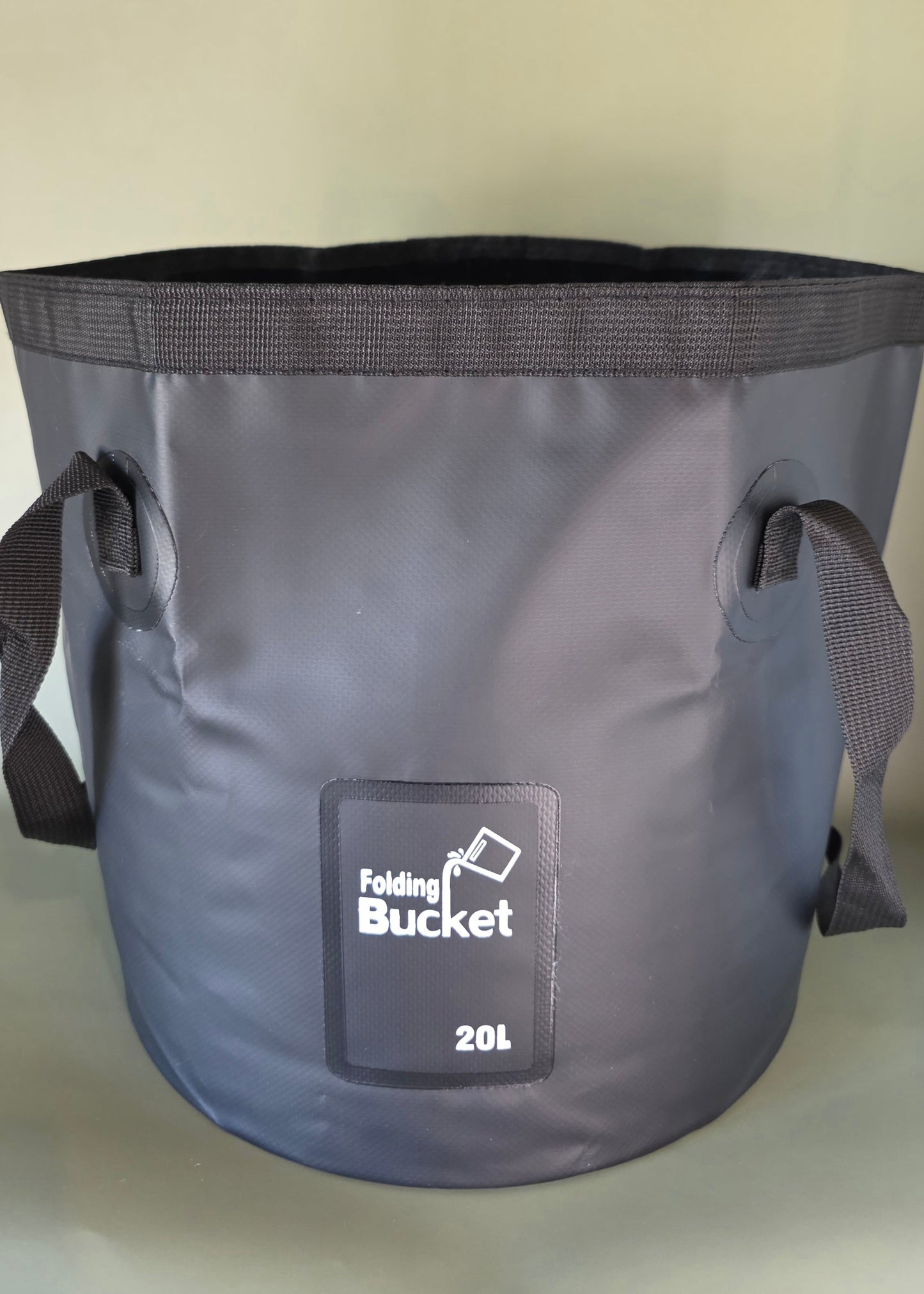 Black folding bucket with handles with a capacity of 20L on an olive background