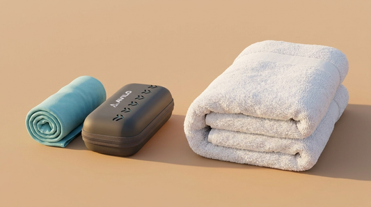 Compact rolled microfibre travel towel beside a bulky white cotton towel showing the size difference