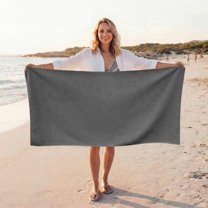 Woman holding a grey towel on a beach
