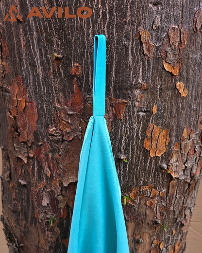 Turquoise towel hanging on a tree with 'Avilo' branding.