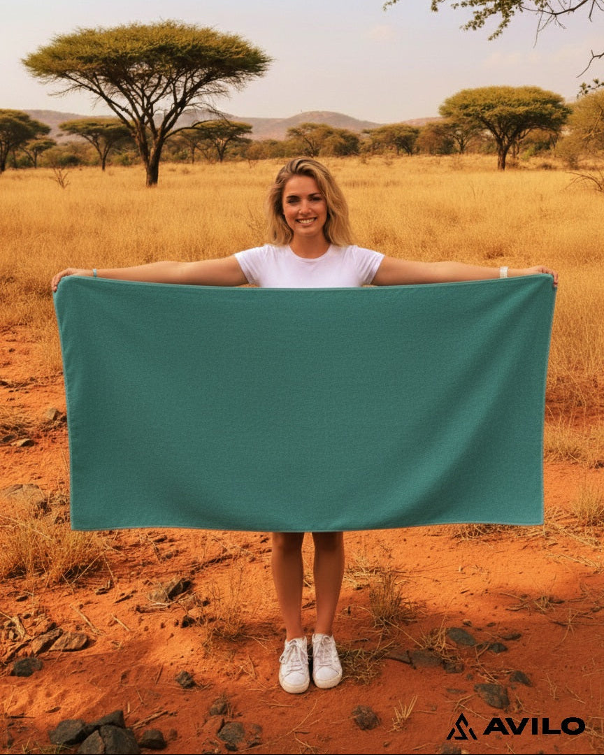 Woman holding a teal towel in a savannah landscape with 'Avilo' branding.