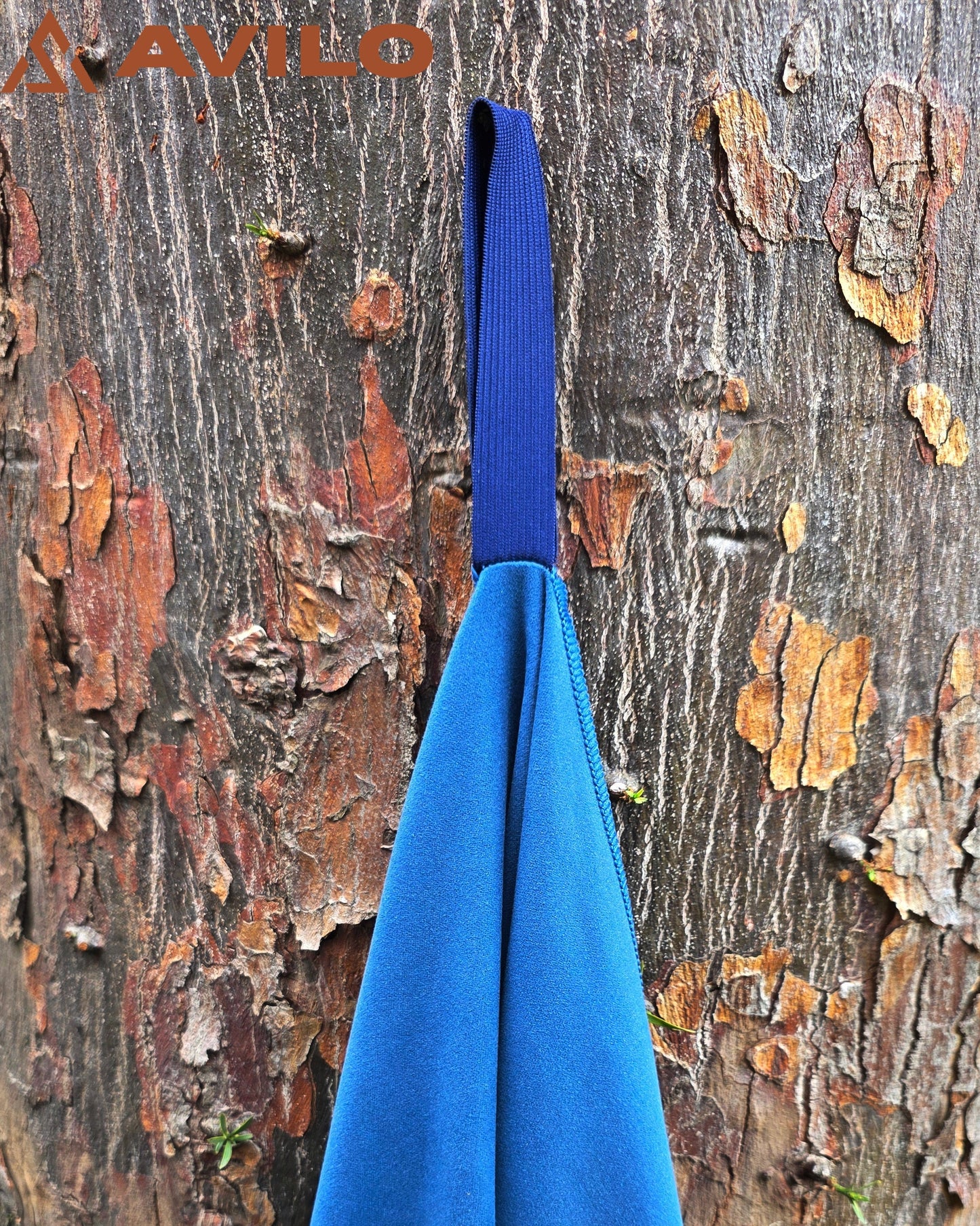 Blue fabric hanging on a tree branch with 'Aivilo' branding.