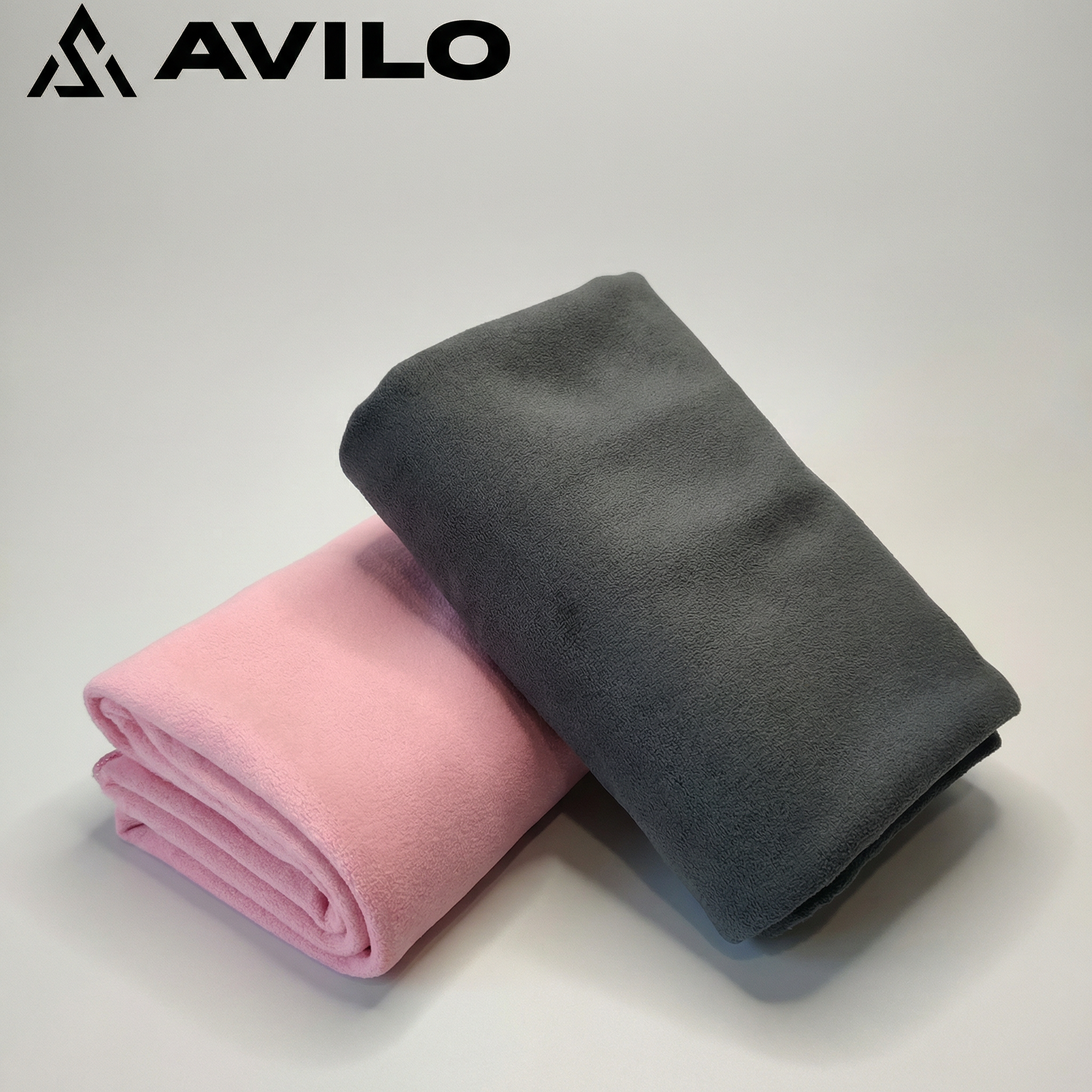 Two folded towels, one pink and one gray, on a light background with 'AVILO' branding.