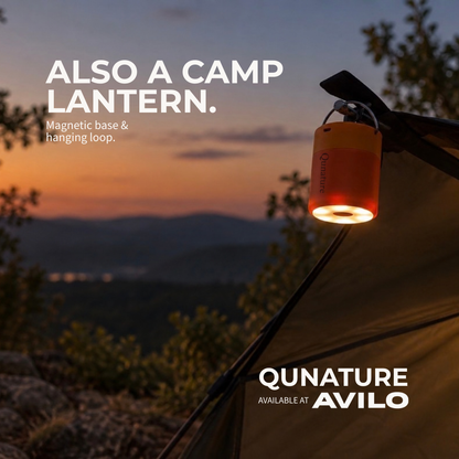 The orange pump hanging from a tent pole at dusk, lit up as a camp lantern with its magnetic base and hanging loop